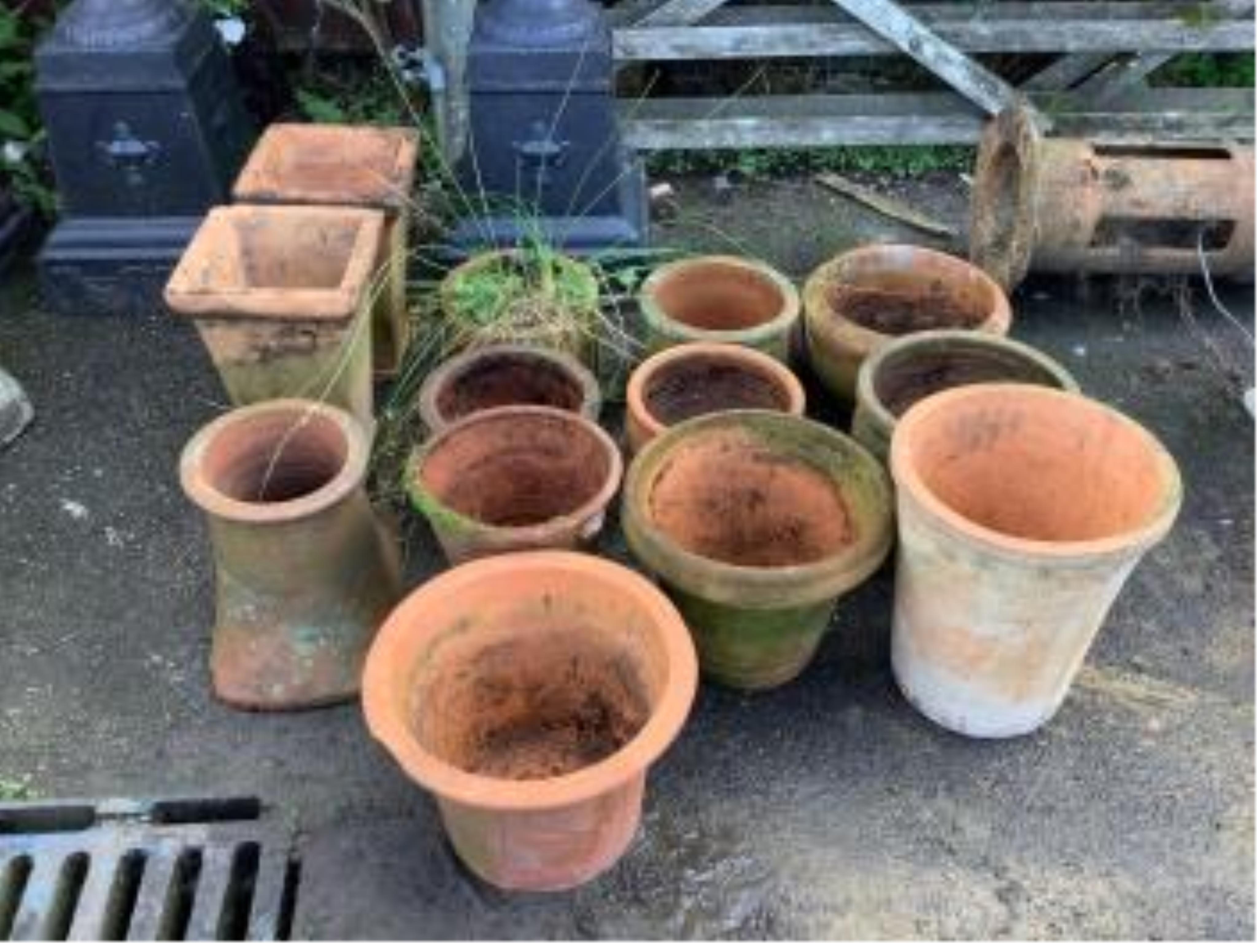 Twenty assorted terracotta planters, largest height 40cm, diameter 42cm, a terracotta pedestal, height 73cm, and a chimney cowl. Condition - all planters weathered, some with chips and losses, pedestal with top corner br